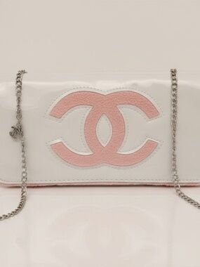 Chanel Beauty Bag features a white patent leather exterior with a prominent pink